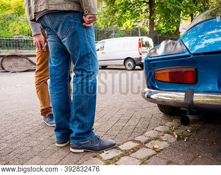 Strasbourg, France - Oct 1, 2017: Male Couple Admiring On French Street With Vintage Blue Alpine A11