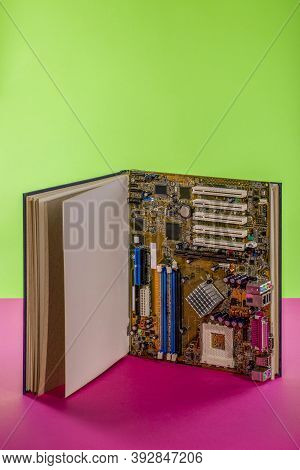 Computer Motherboard In A Large Open Book On A Colored Background