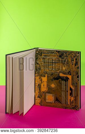 Computer Motherboard In A Large Open Book On A Colored Background
