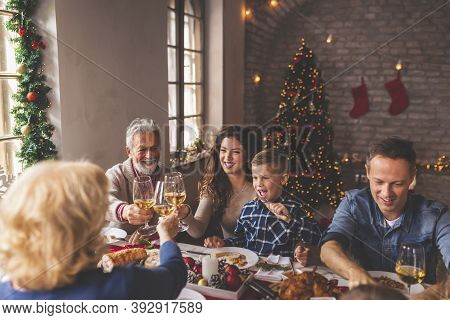 Beautiful Happy Family Gathered Around The Table, Having Christmas Dinner All Together At Home, Cele