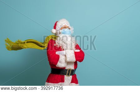 Merry Christmas and Happy Holidays! Santa Claus in face mask on bright color background. Covid-2019