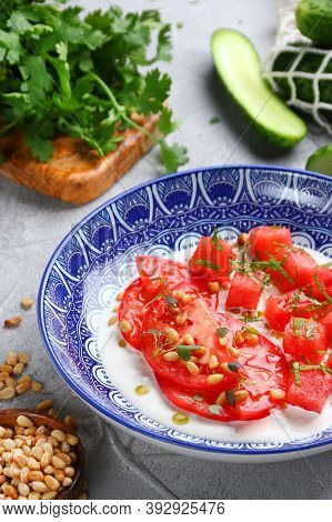Stracciatella Salad With Tomatoes And Watermalone And Ingredients On Light Concrete Table