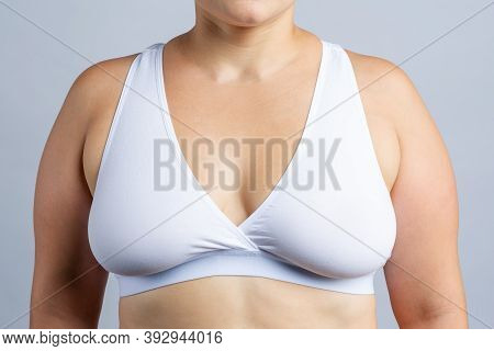 Big Natural Breasts In White Bra Close-up On Gray Background