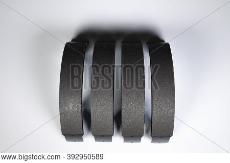 New Set Of Four Brake Pads For Drum Brakes On A Gray Background