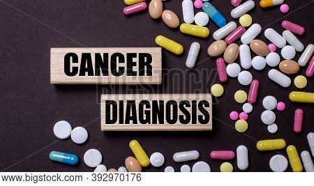 Cancer Diagnosis Is Written On Wooden Blocks Near Multi-colored Pills. Medical Concept