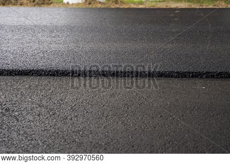 A Large Layer Of Fresh Hot Asphalt. Layer Of Asphalt Raw Material In A Shallow Depth Of Field. Rolle