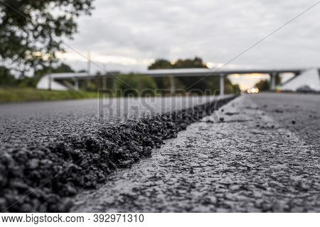 A Large Layer Of Fresh Hot Asphalt. Layer Of Asphalt Raw Material In A Shallow Depth Of Field. Rolle