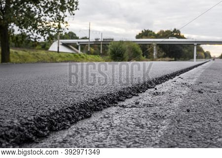 A Large Layer Of Fresh Hot Asphalt. Layer Of Asphalt Raw Material In A Shallow Depth Of Field. Rolle