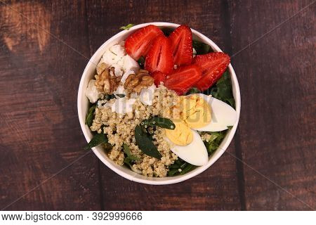 Delicious Helty Salad On A White Pot On A Wooden Table. Top View