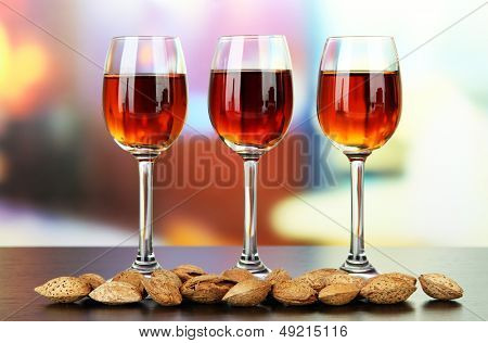 Sklenice likéru amaretto a pražených mandlí, na světlé pozadí