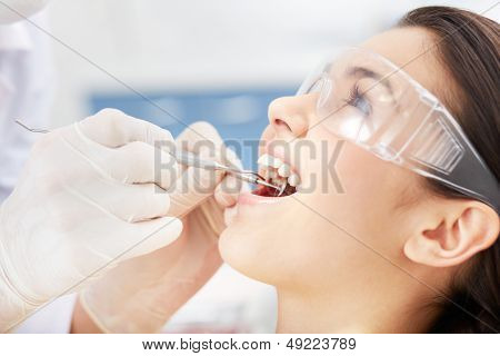 Close-up of girl with open mouth during oral checkup at the dentistÃ?ÃÂ¢??s