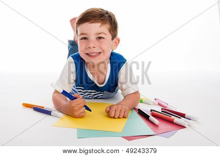 Young Boy Drawing On Colored Paper.
