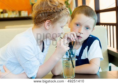 boy and girl drinking a drink with ice