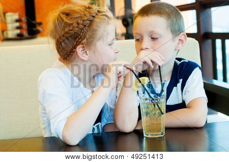 boy and girl drinking a drink with ice