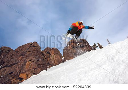 Snowboarder jumping through air with deep blue sky in background