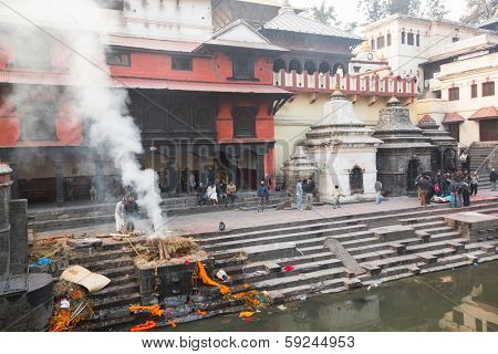 KATHMANDU, NEPAL - DEC 20: During the cremation ceremony along the holy Bagmati River in Bhasmeshvar Ghat at Pashupatinath temple, Dec 20, 2013 in Kathmandu, Nepal.