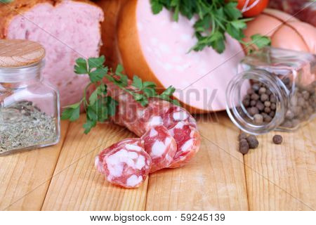 Lot of different sausages on wooden table on natural background