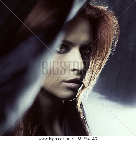 Portrait of young attractive woman in the darkness