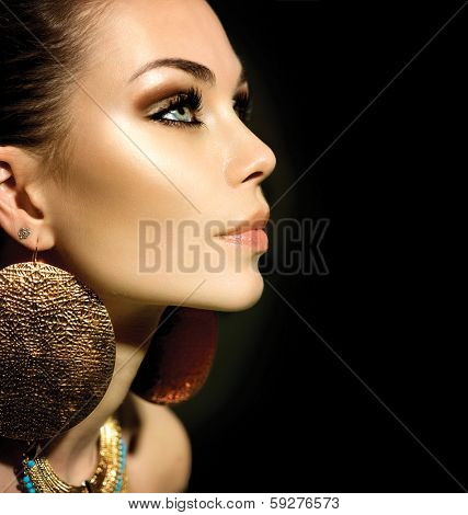 Fashion Woman Profile Portrait isolated on black. Golden Jewels. Trendy Makeup. Smoky eyes make up. Gold Jewellery. Accessories 