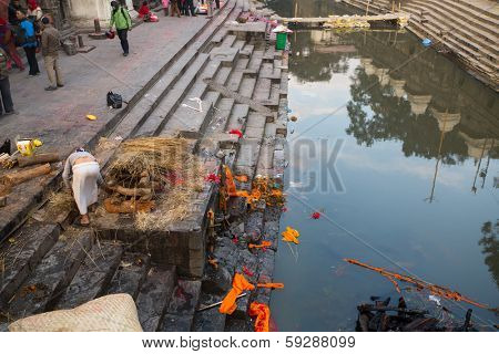 KATHMANDU, NEPAL - DEC 20: During the cremation ceremony along the holy Bagmati River in Bhasmeshvar Ghat at Pashupatinath temple, Dec 20, 2013 in Kathmandu, Nepal.