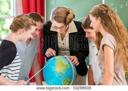 Students or pupils having group work while geography lesson and the teacher test or educate them in school or class