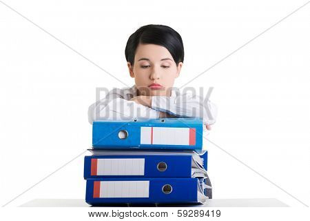 Sad woman with ringbinders sitting at the desk. Tired and exhousted business woman. 