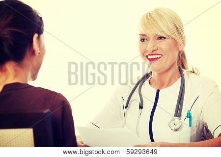 Mature female doctor talking with her patient. 