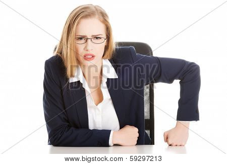 Attractive business woman by the table, bossy behaviour. Isolated on white.