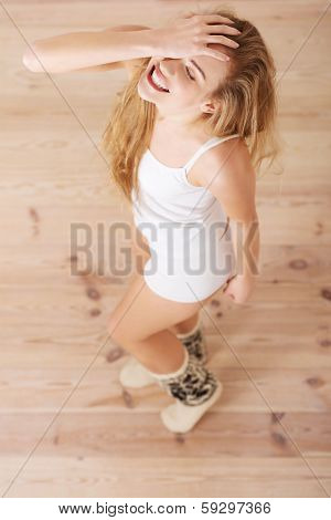 Cheerful, carefree young caucasian woman feels happy. Standing, or dacing, posing over wooden floor.