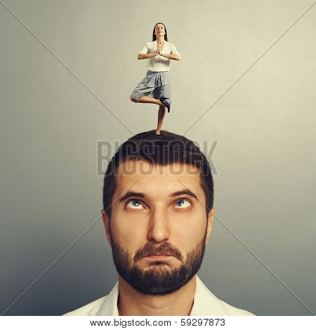 small meditation woman standing on the head of foolish man