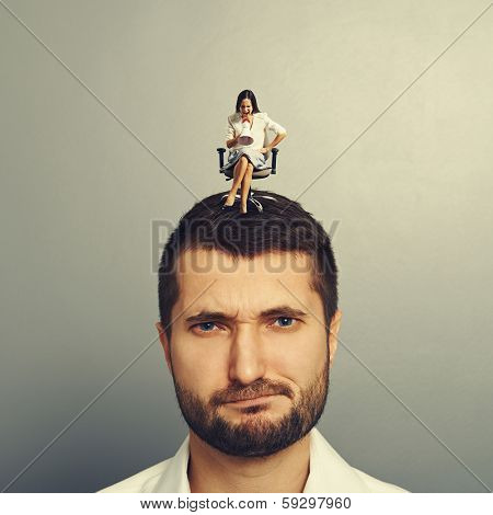 angry small woman screaming at discontented man over grey background