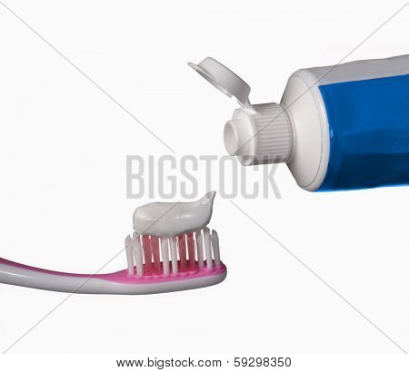 toothbrush and toothpaste tube on white background.Toothpaste being squeezed onto toothbrush.