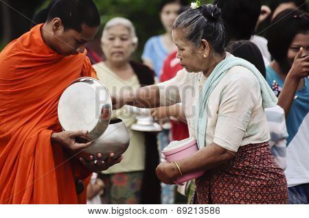 An unidentified women Gives food offerings to a Buddhist monk