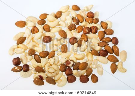 mixed nuts - hazelnuts walnuts cashews pine nuts isolated on white background