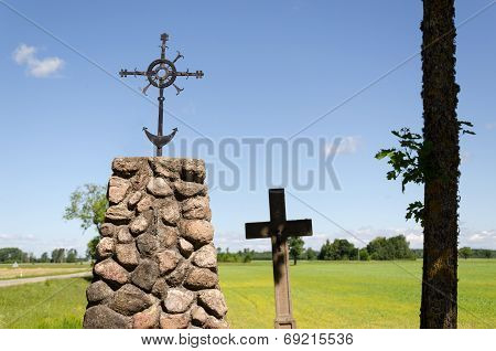 Stone Monument With Metal Squirm Cross In Nature