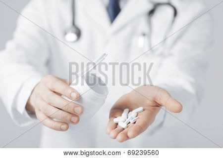 picture of doctor hands holding white pack and pills