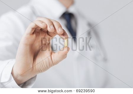 picture of doctor hand showing one capsule
