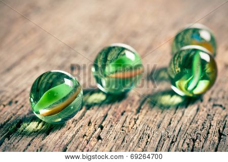 Glass marble balls on old wooden background