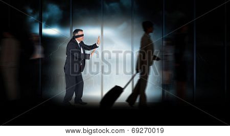 Mature businessman in a blindfold against room with large window looking on city