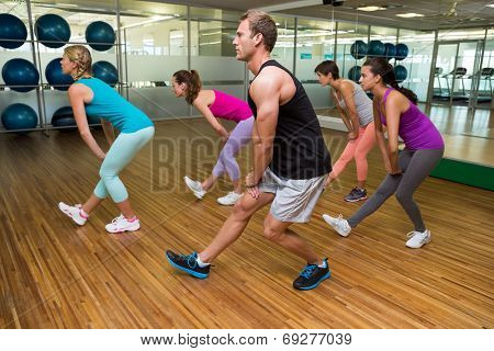 Fitness class led by handsome instructor at the gym