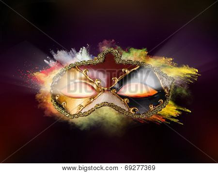 Isolated Venice mask with freeze motion of colored powder on black background