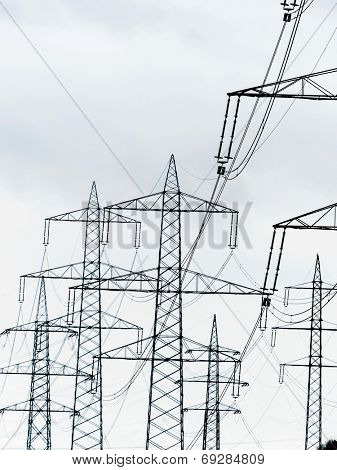 the mast of a high voltage transmission line for electricity before dark clouds.