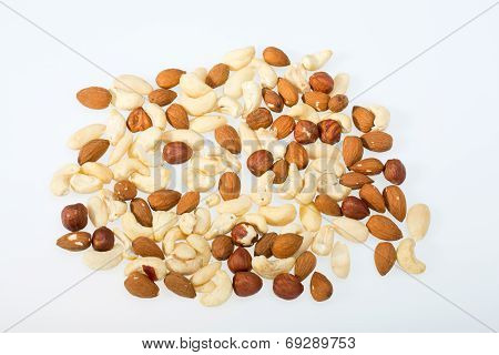 mixed nuts - hazelnuts walnuts cashews pine nuts isolated on white background