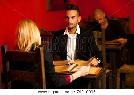 Young Couple Ordeting Food In Restaurant Reading Menu