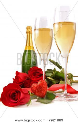 Copos de champanhe com rosas vermelhas e pequeno coração