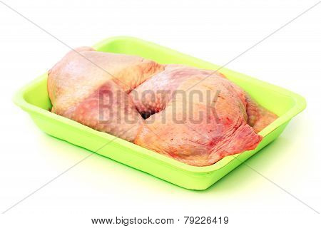 Raw chicken legs in a green tray