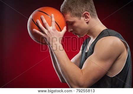 Caucasian male basketball player pressing ball to his forehead