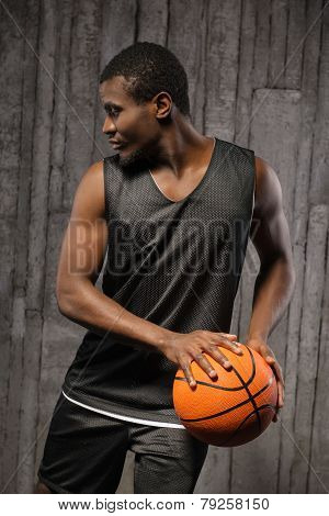 Afro-american muscular man holding basketball