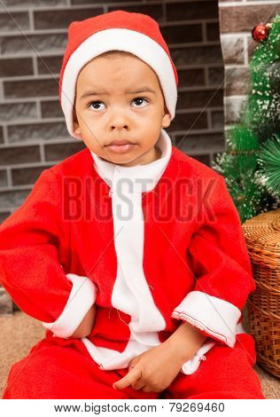 African American Boy Dressed Costume Santa Claus By Fireplace. Christmas And New Year