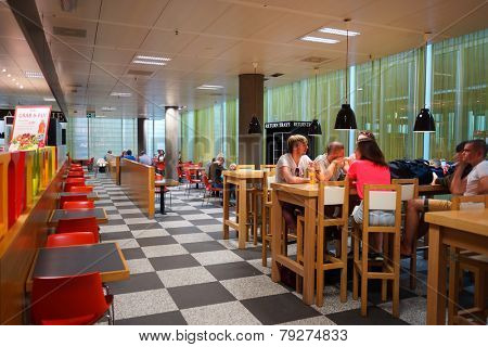GENEVA - SEP 11: people in airport cafe on September 11, 2014 in Geneva, Switzerland. Geneva International Airport is located 4 km northwest of the city centre